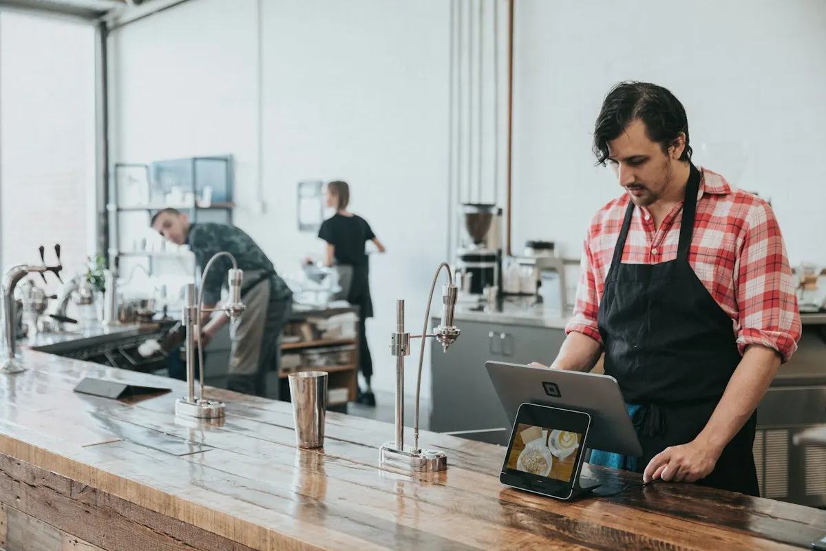 Dueño de una cafetería revisando su caja en una tablet